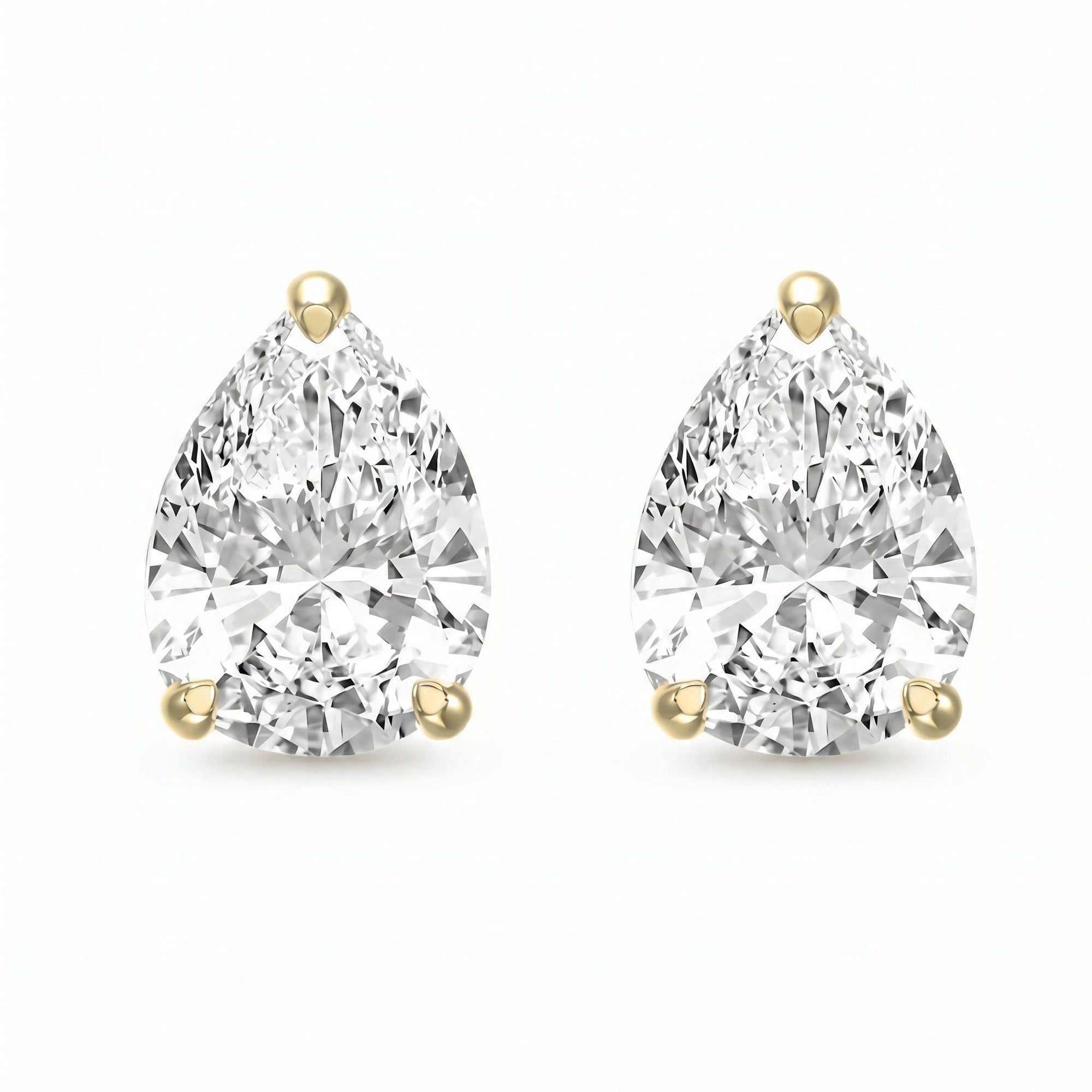 Pair of pear-shaped diamond earrings with gold prongs on a white background