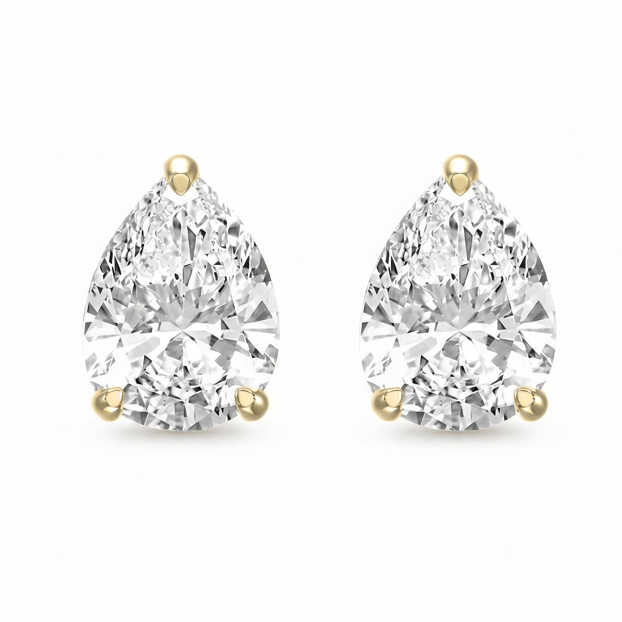 Pair of pear-shaped diamond earrings with gold prongs on a white background