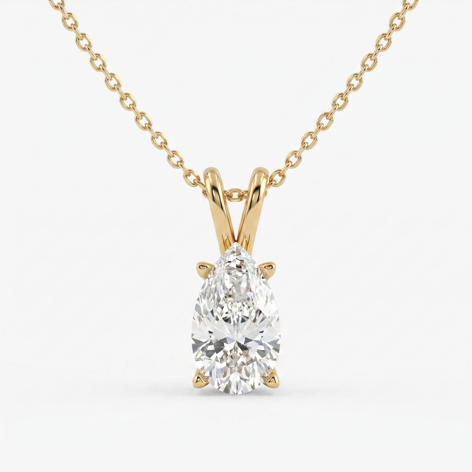 Gold necklace with a pear-shaped diamond pendant on a white background