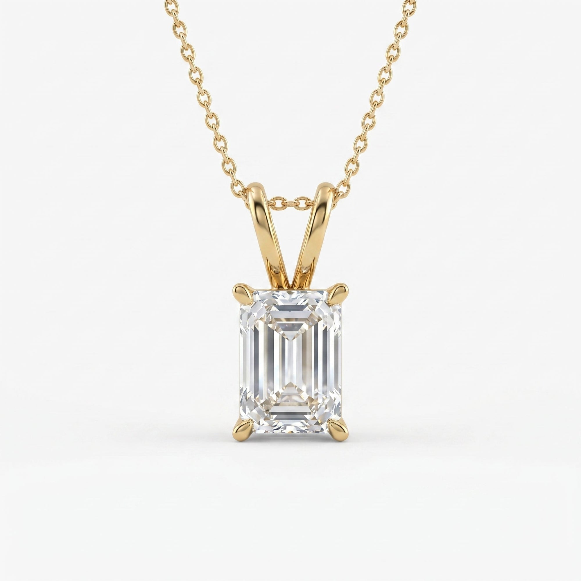 Emerald cut solitaire pendant necklace in polished yellow gold with clear faceted gemstone on white background