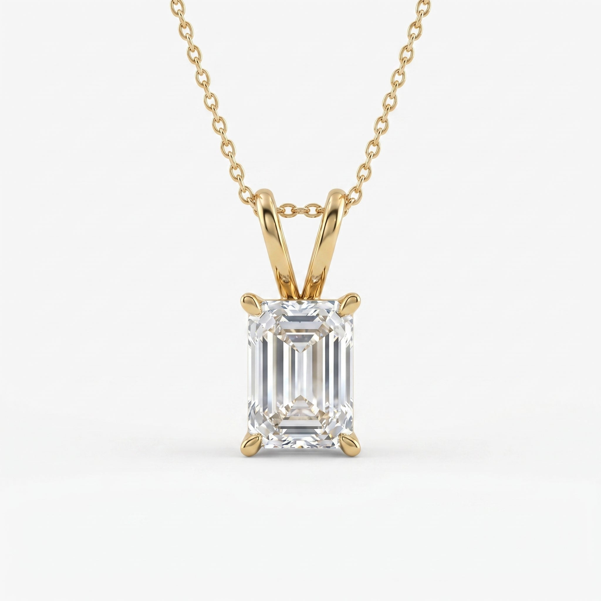 Emerald cut solitaire pendant necklace in polished yellow gold with clear faceted gemstone on white background