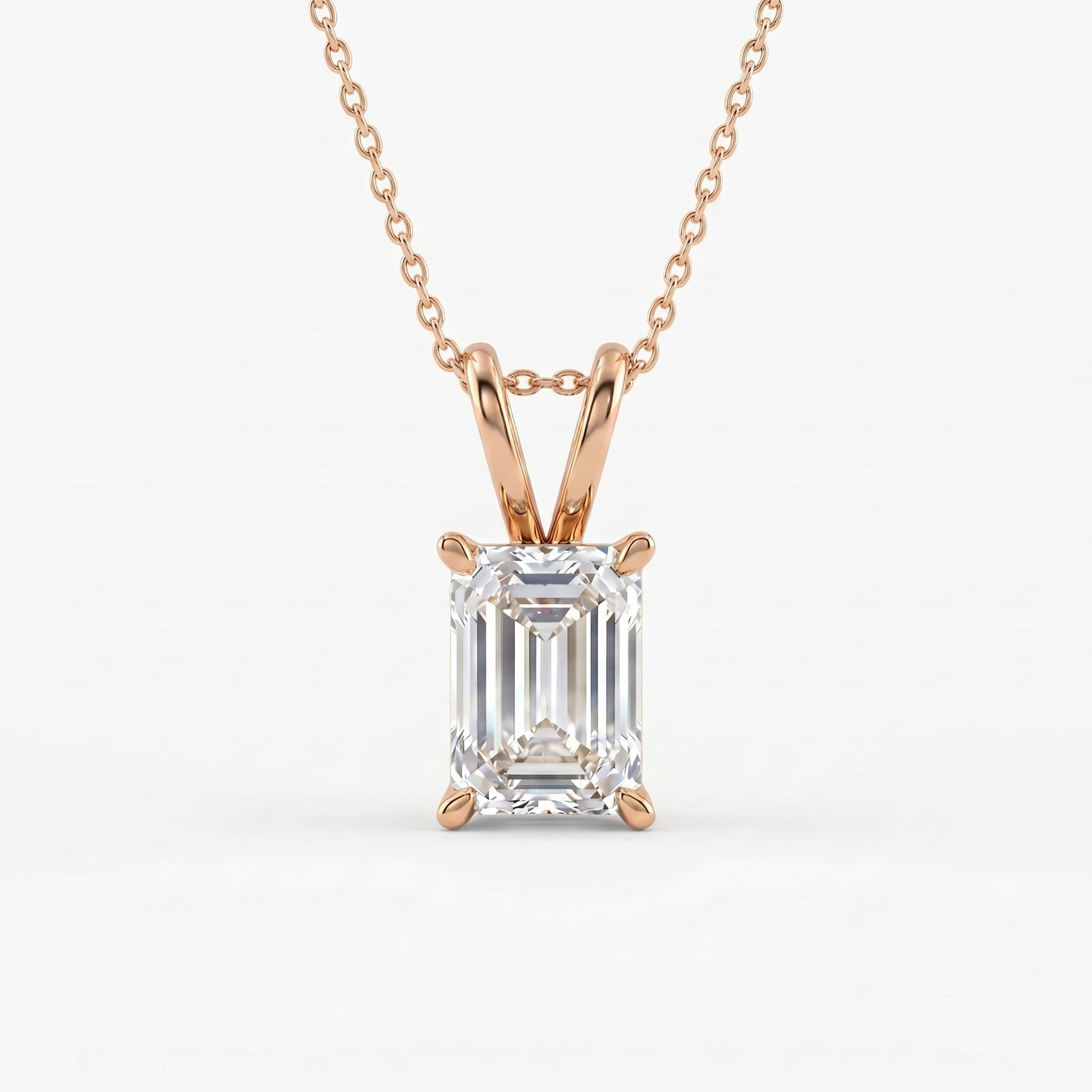 Rose gold necklace with an emerald-cut diamond pendant on a white background