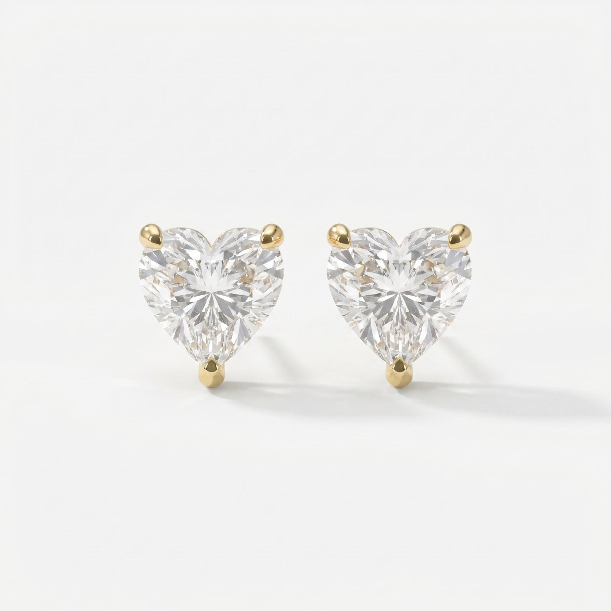 Heart-shaped diamond earrings on a white background