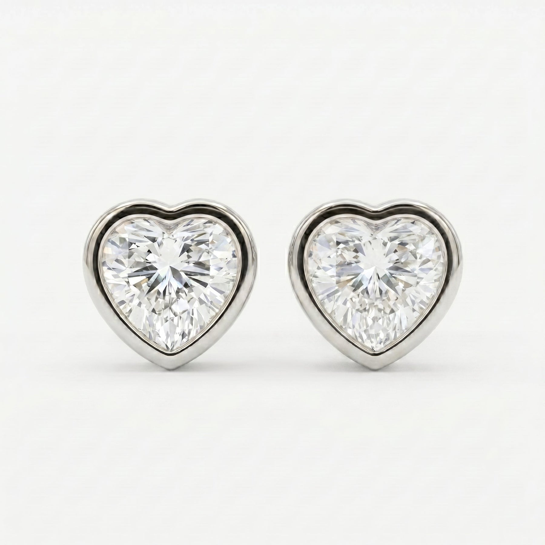 Heart-shaped diamond earrings on a white background