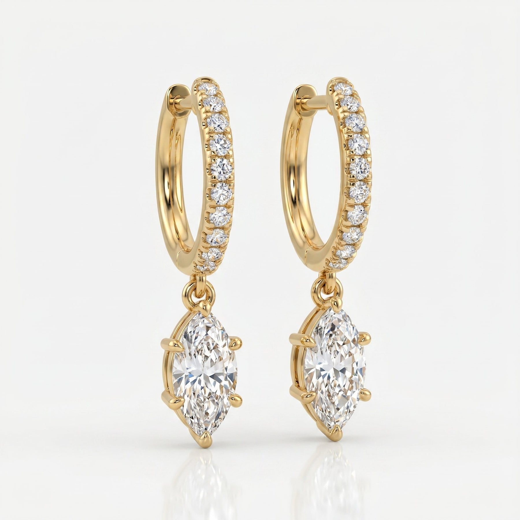 Luxury yellow gold hoop earrings with dangling marquise diamonds photographed at elegant 45-degree angle