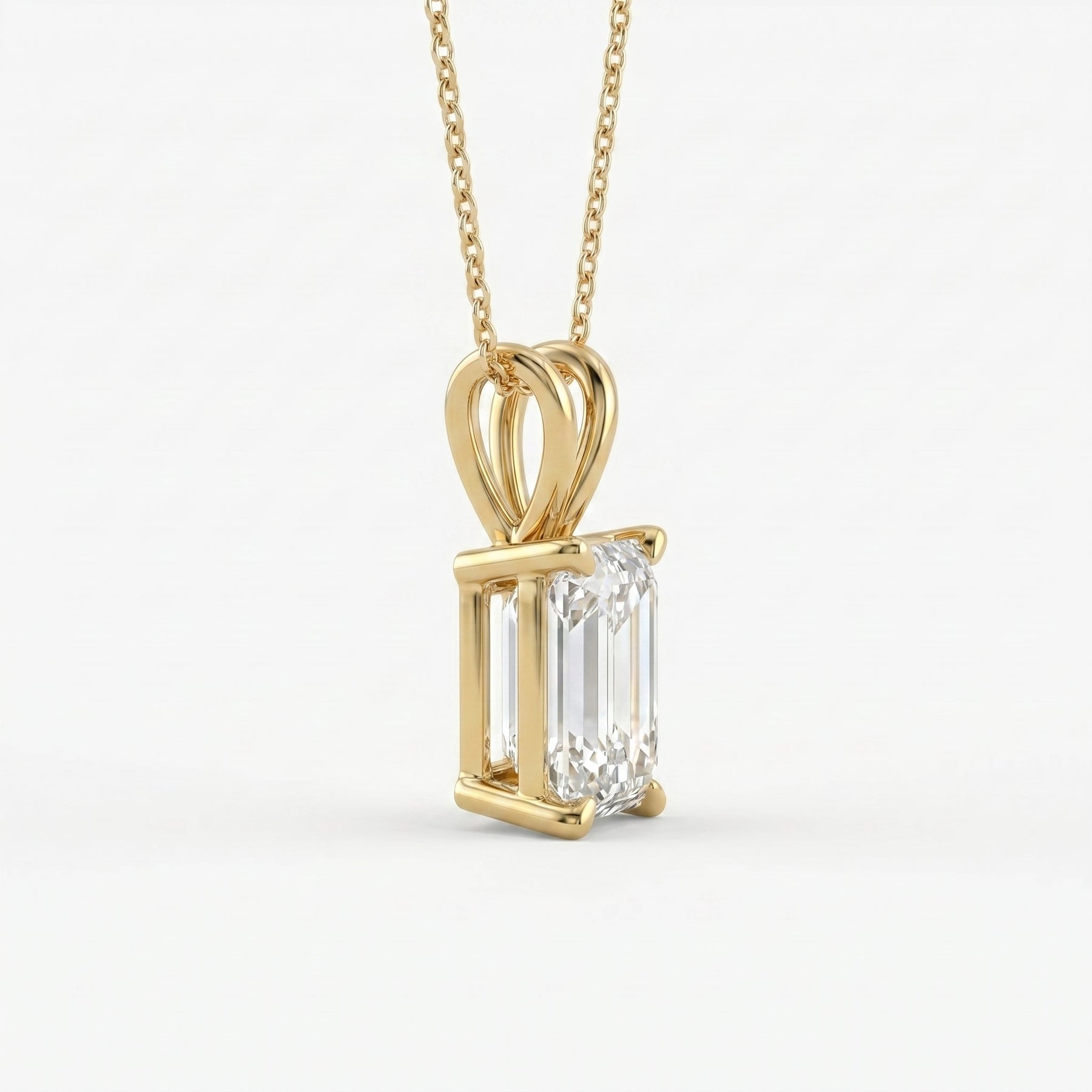 Gold pendant with a rectangular diamond on a white background