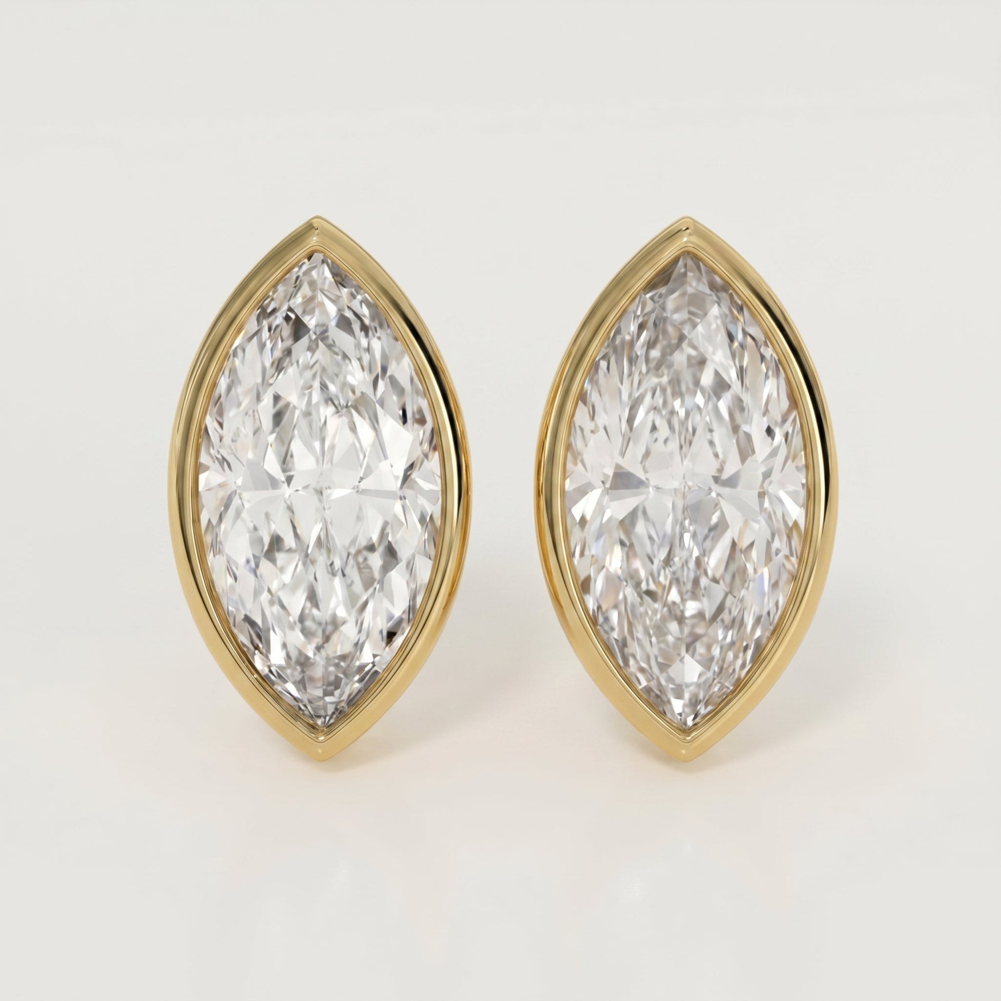 Pair of diamond earrings with gold settings on a light gray background
