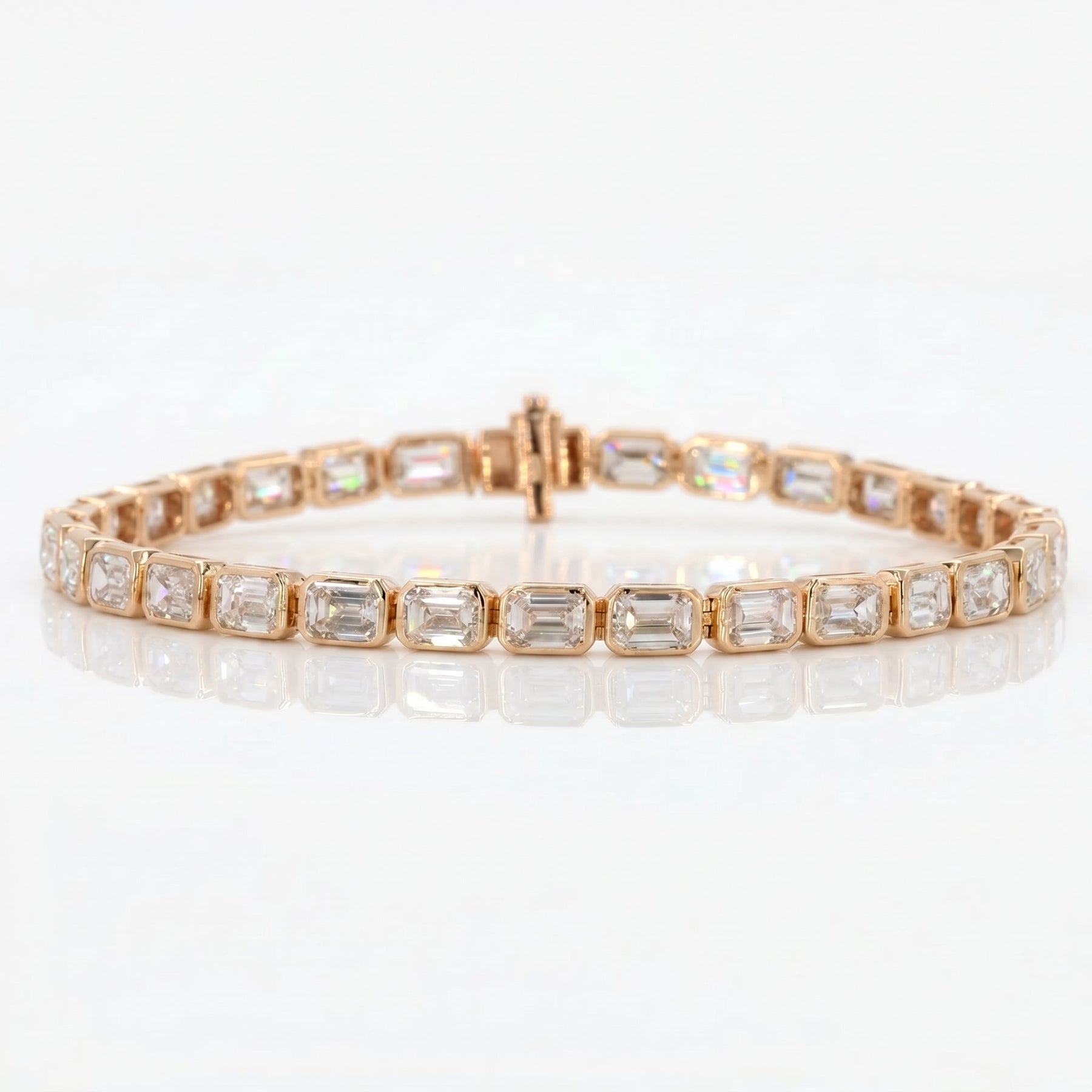 Rose gold bracelet with emerald-cut gemstones on a white background