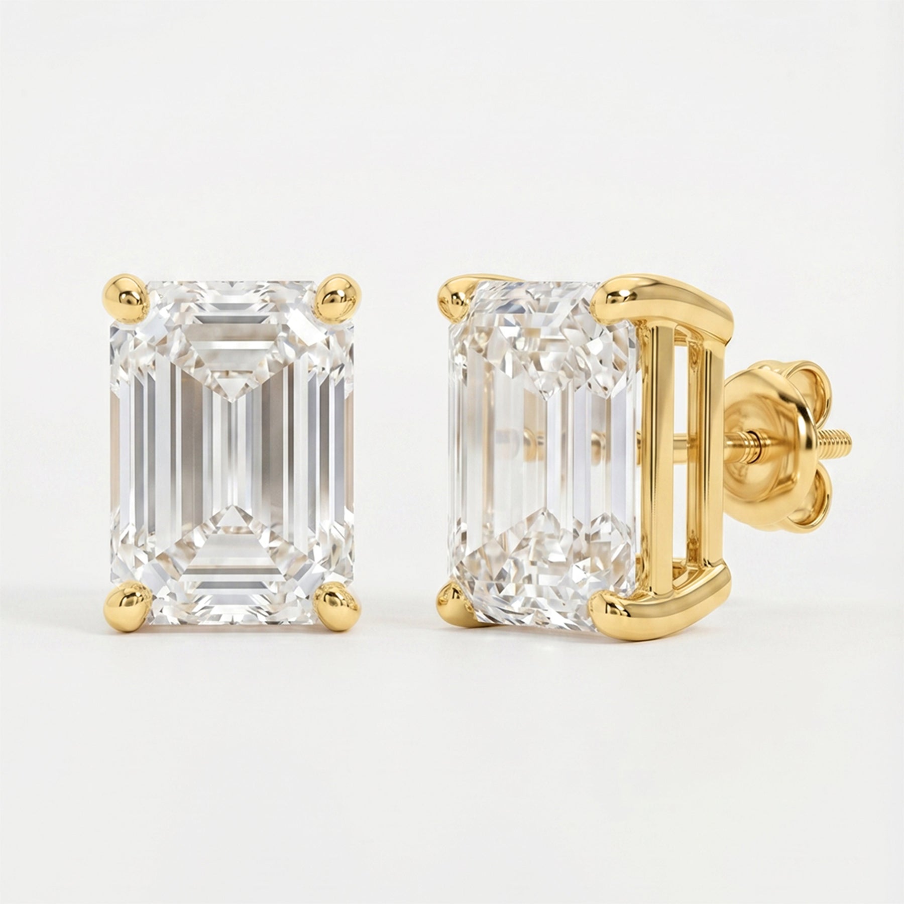 Gold emerald-cut diamond earrings on a light gray background