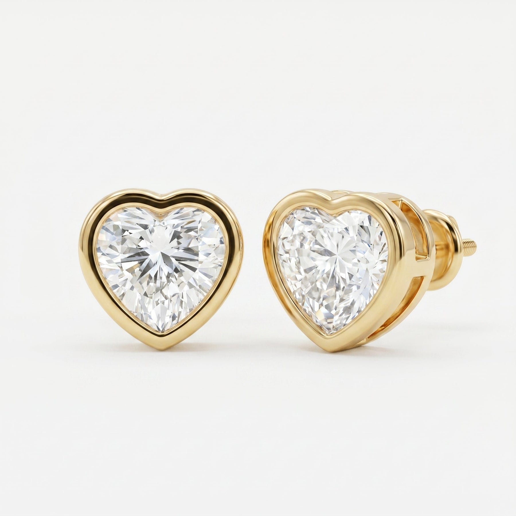 Heart-shaped diamond earrings with gold setting on a white background