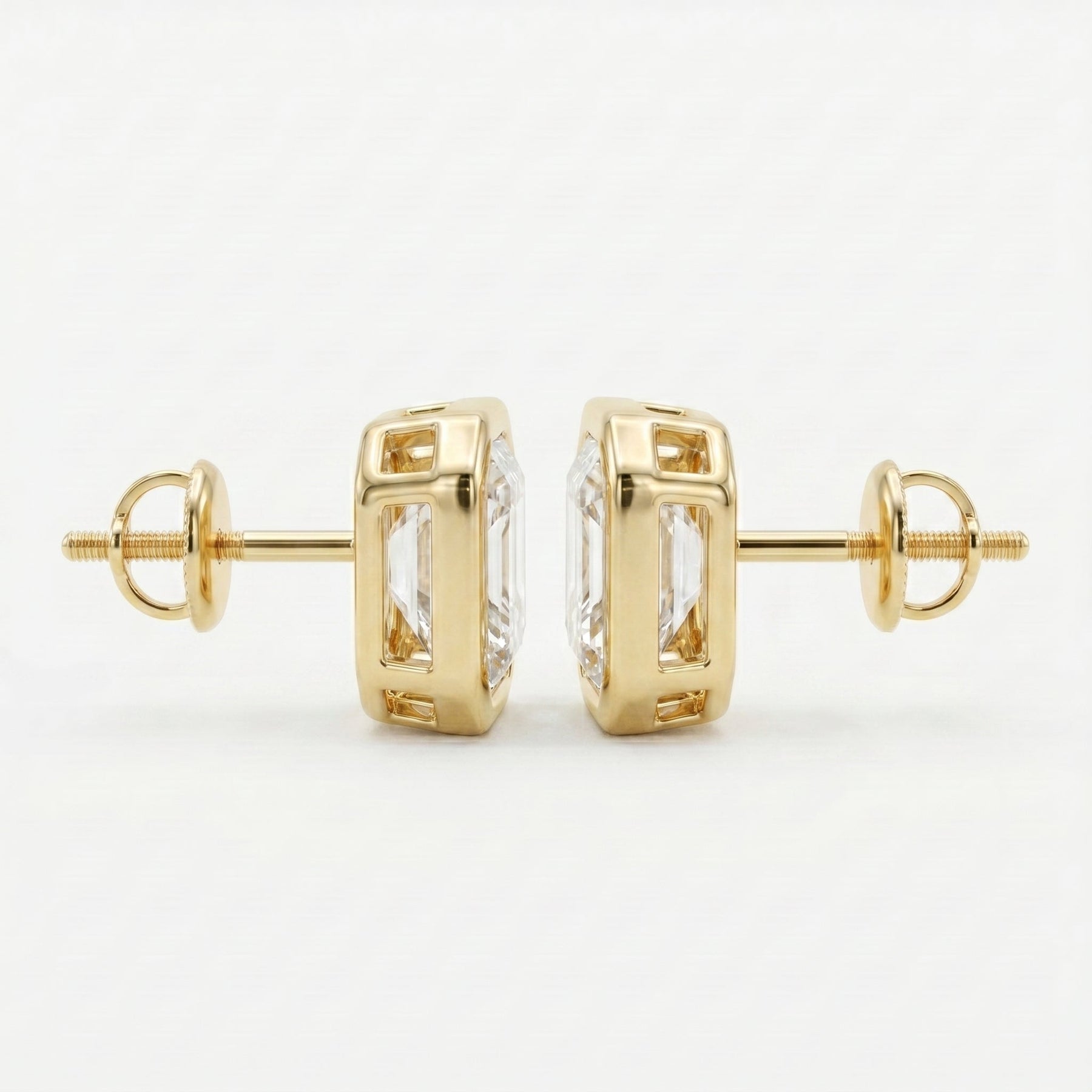 Gold earrings with clear gemstones on a white background
