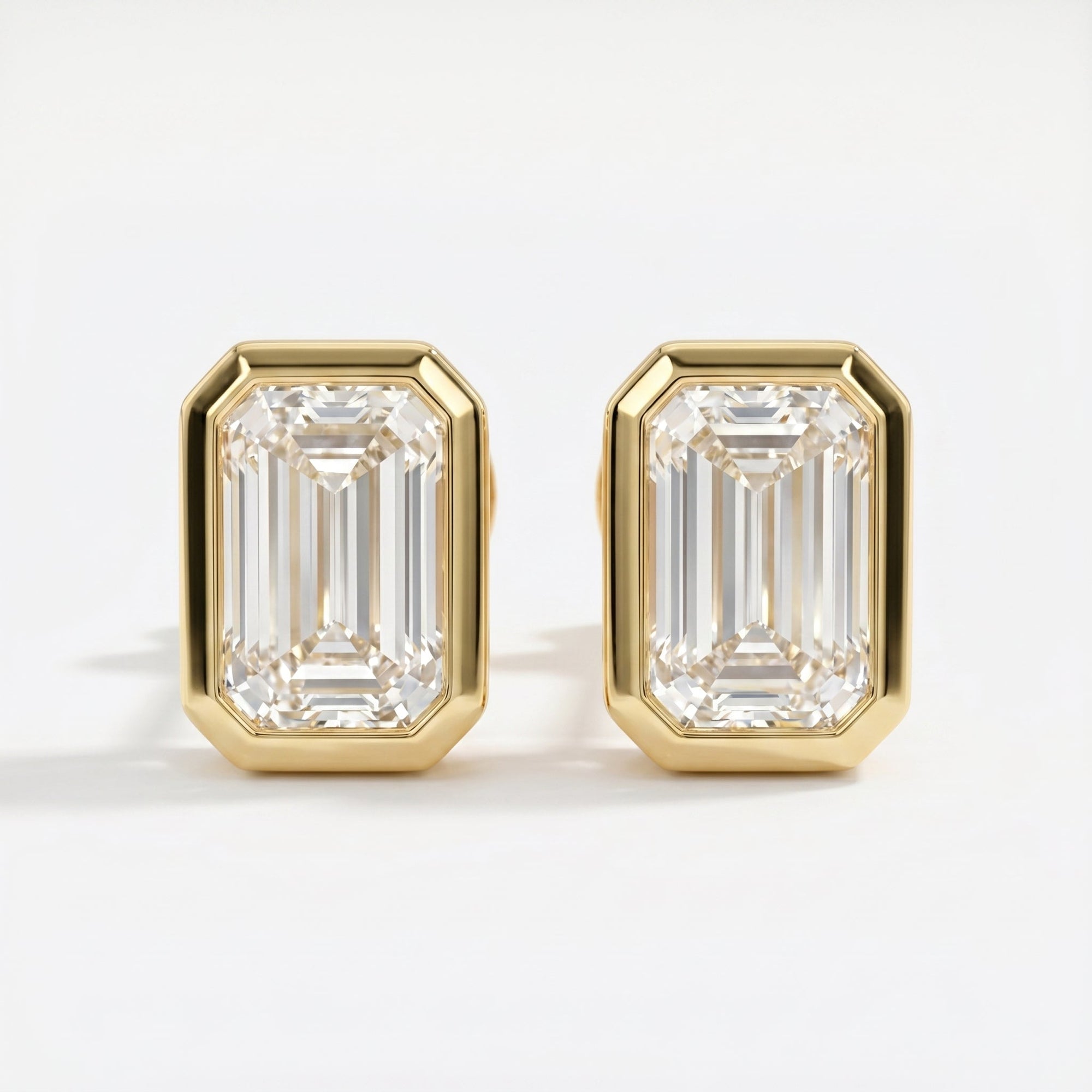 Gold emerald-cut earrings on a white background