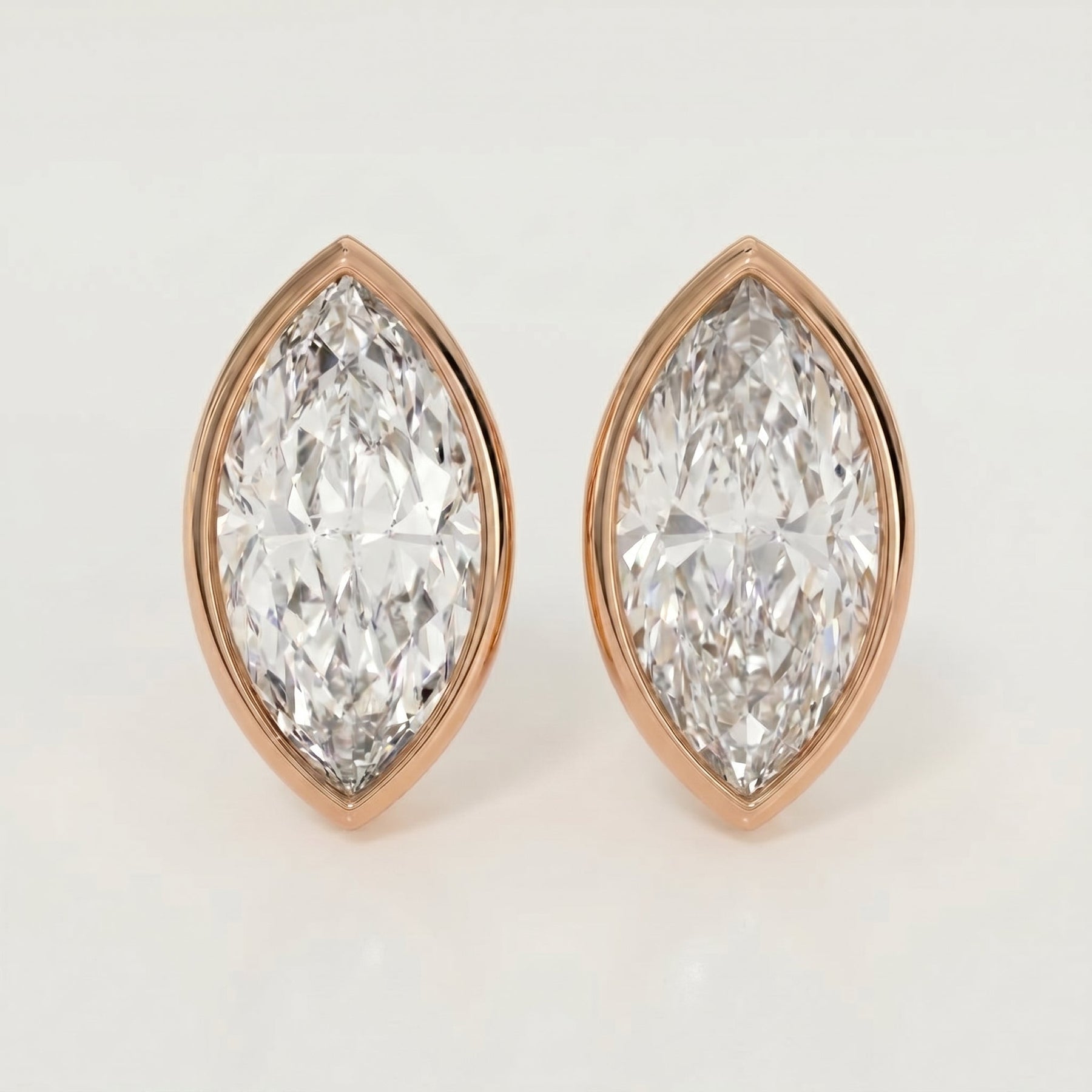 Pair of diamond earrings with rose gold setting on a light gray background