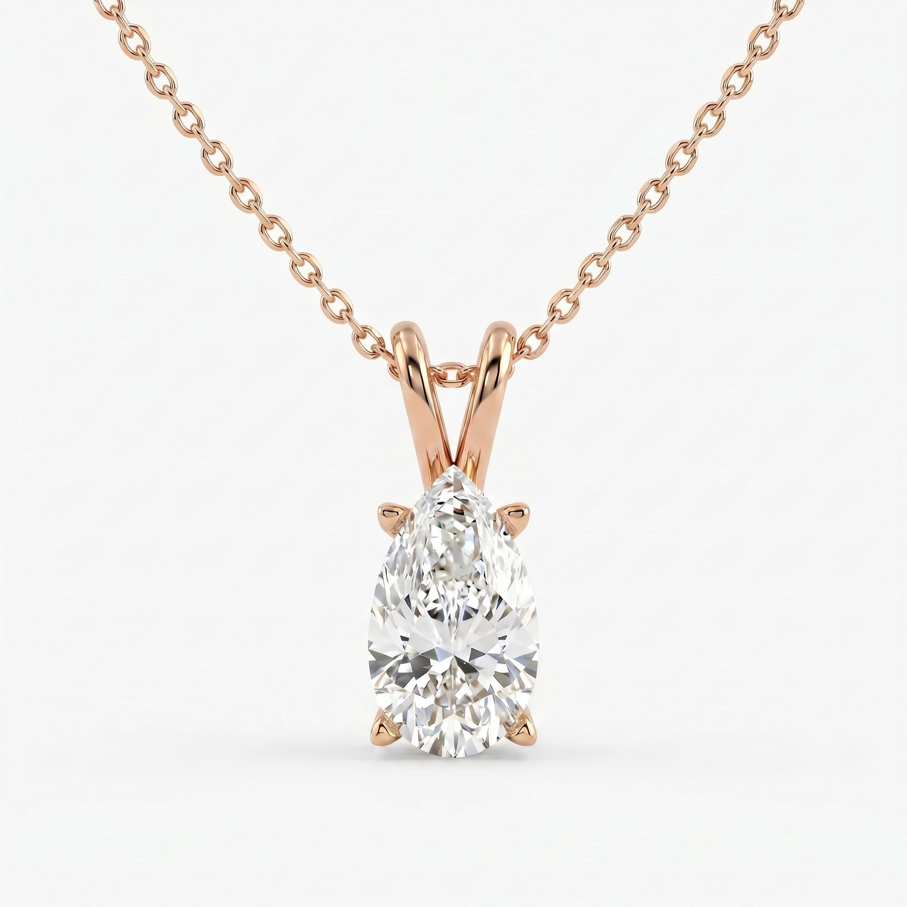 Rose gold necklace with a pear-shaped diamond pendant on a white background