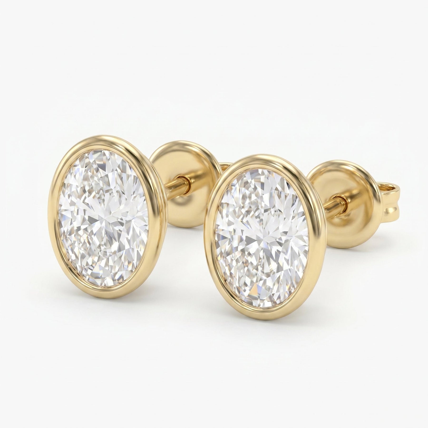 Round diamond bezel stud earrings in polished yellow gold with brilliant sparkle on white background