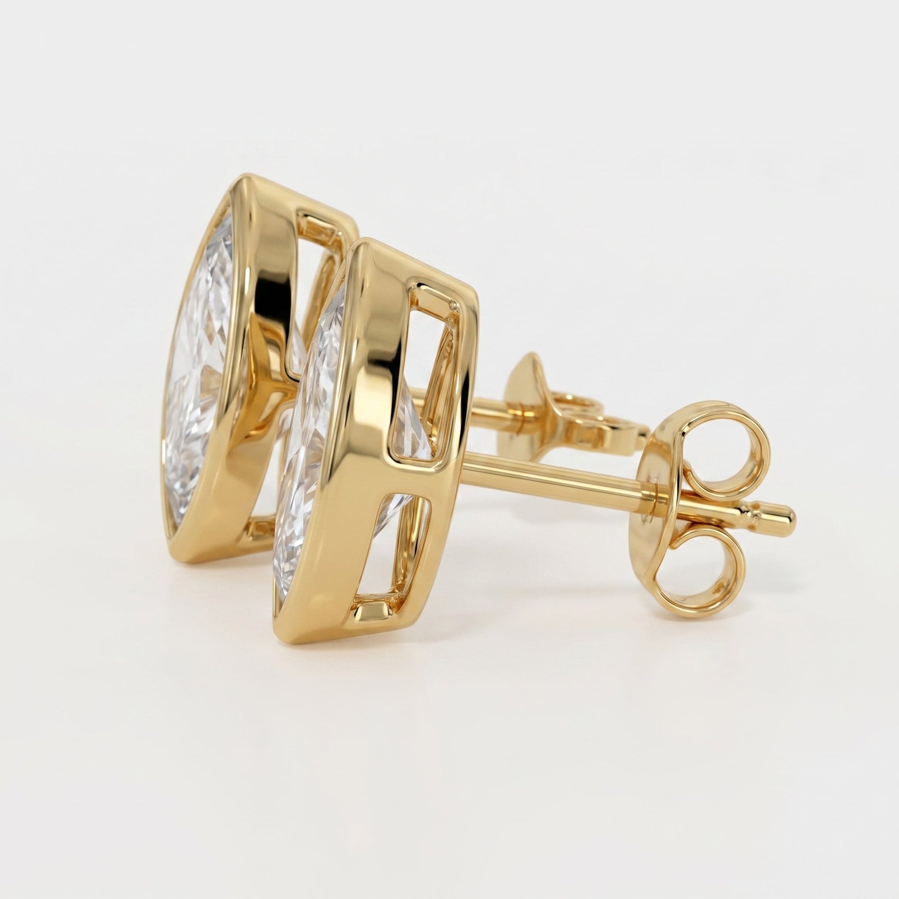 Gold earrings with clear gemstones on a light gray background