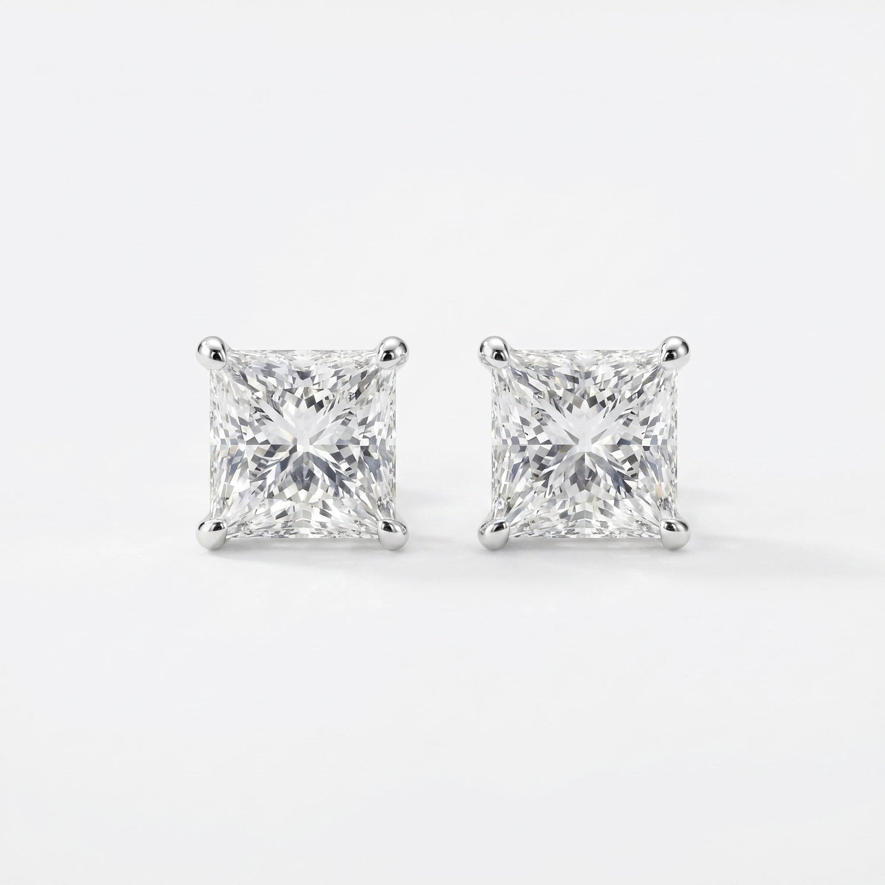 Pair of diamond stud earrings on a white background