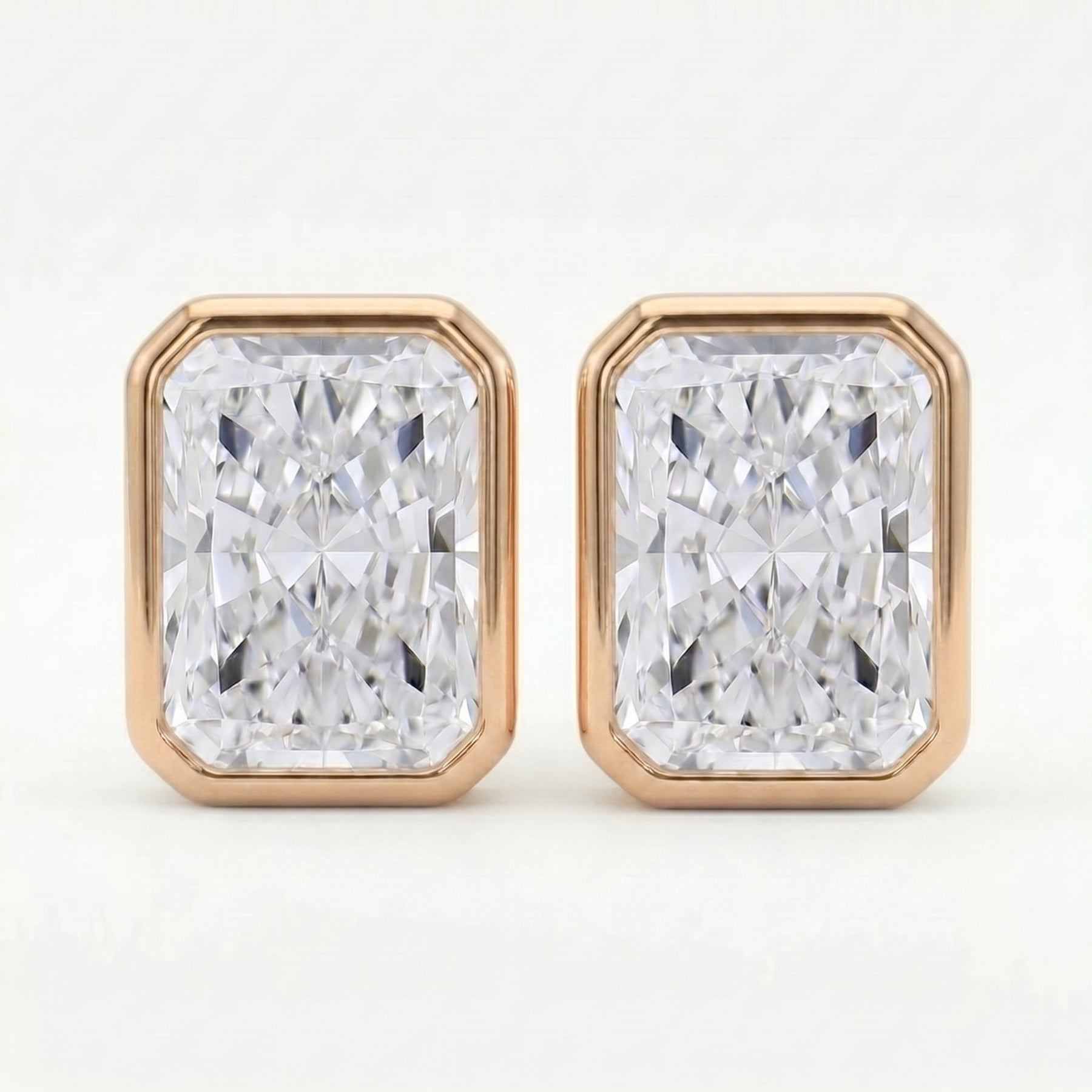 Pair of diamond stud earrings with rose gold frames on a white background
