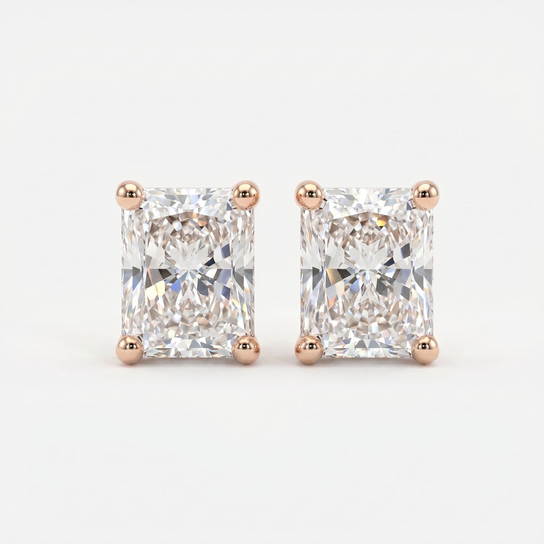 Pair of diamond stud earrings with rose gold prongs on a light gray background