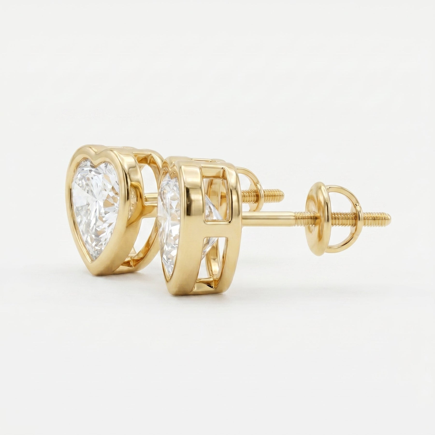 Gold earrings with clear gemstones on a light gray background