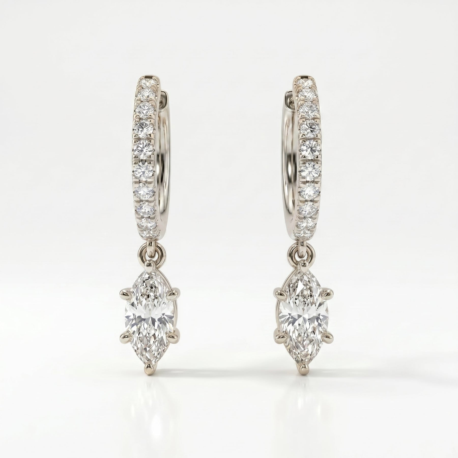 Angled view of White gold diamond drop hoop earrings with marquise-cut dangling center stones