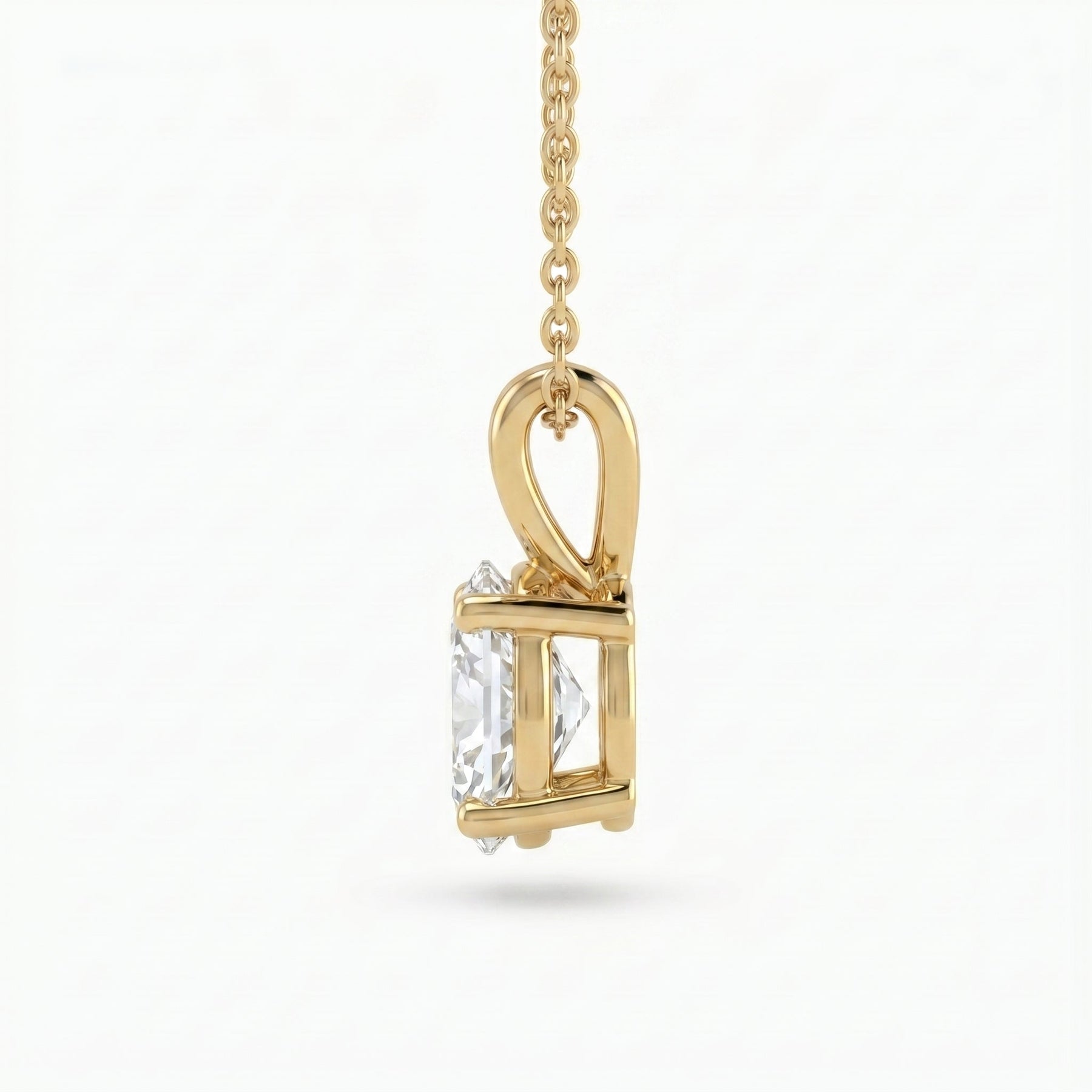 Gold pendant with a clear gemstone on a white background
