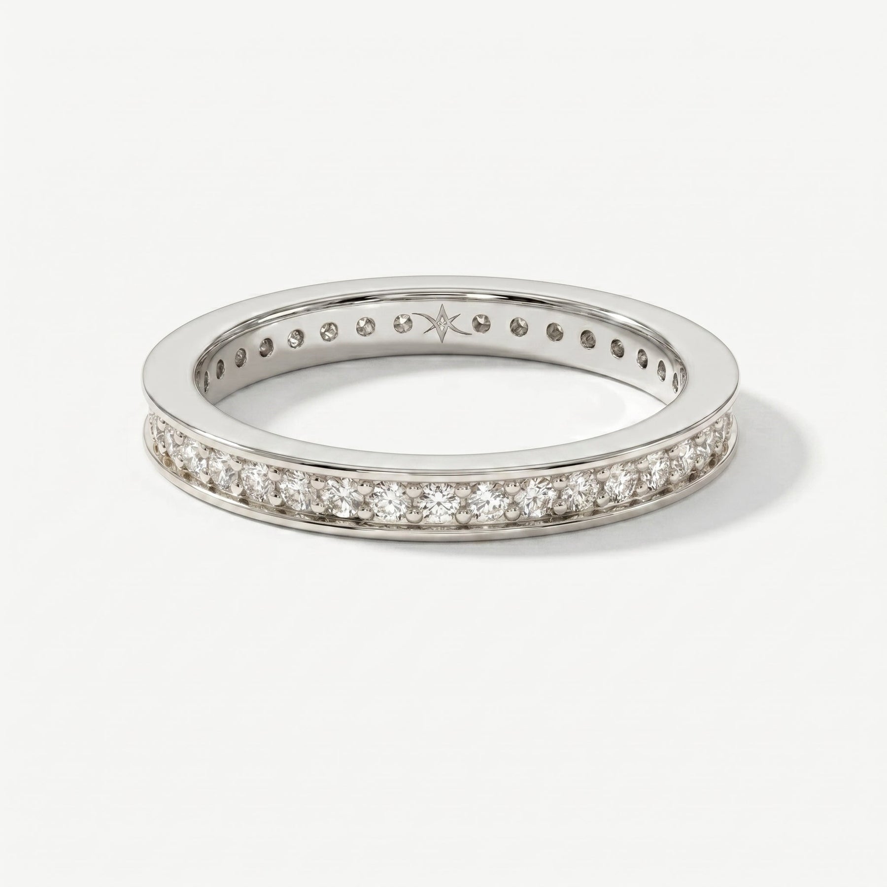 Luxury white gold eternity wedding band featuring channel-set diamonds shown from an elegant angled view