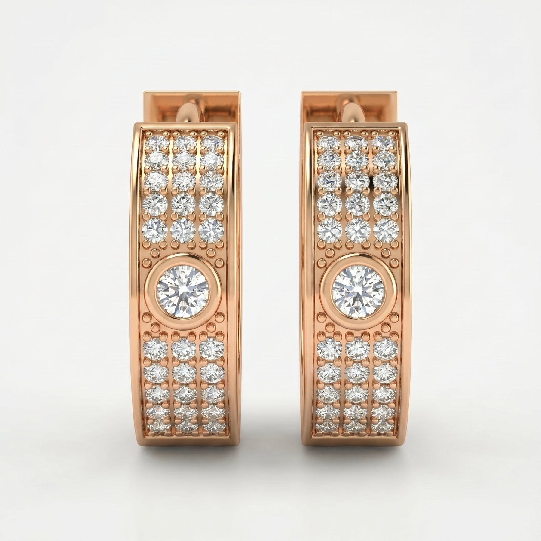 Rose gold diamond huggie hoop earrings with pavé stones and bezel-set center diamonds on white background