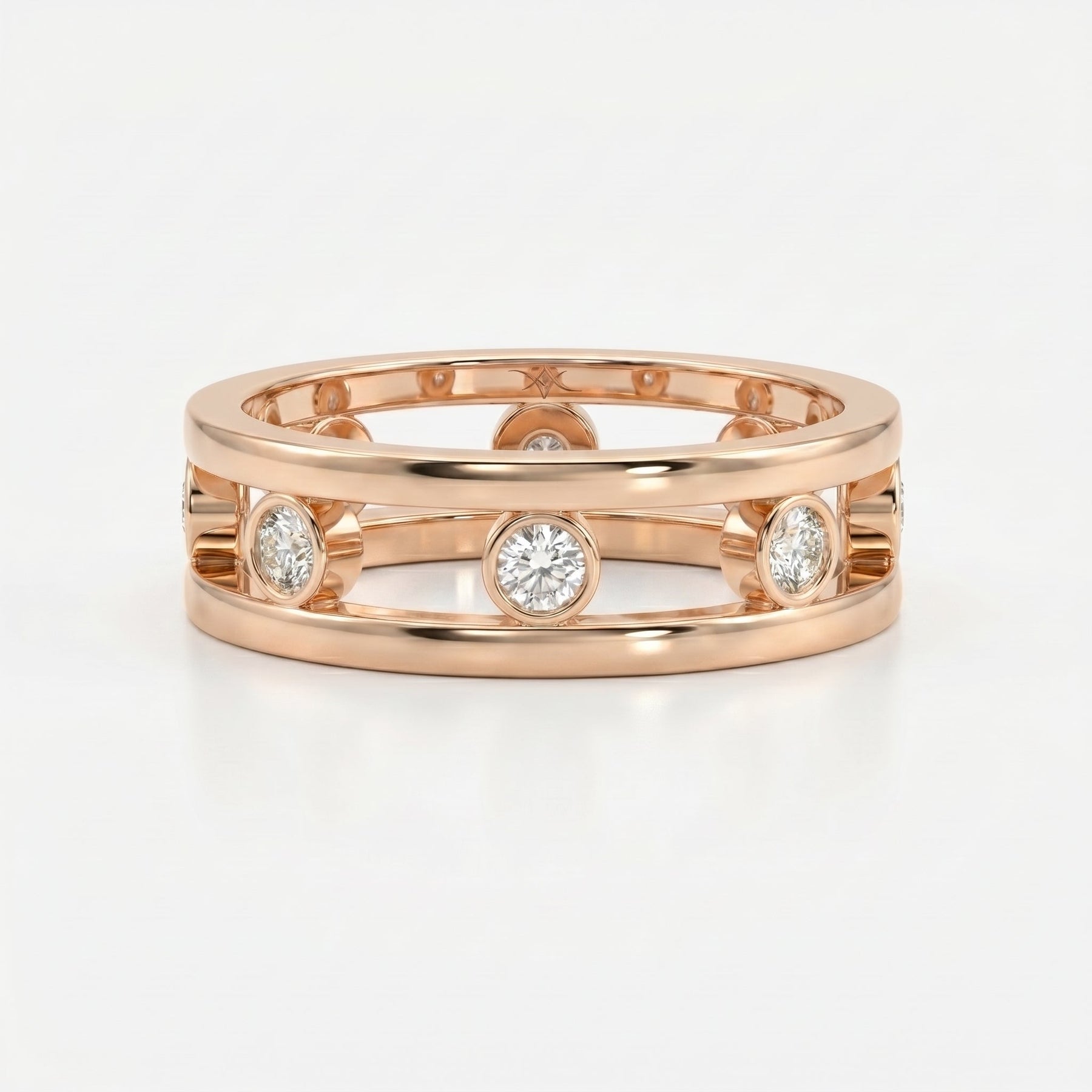 Architectural diamond band ring featuring bezel set round diamonds and open gallery design in polished metal