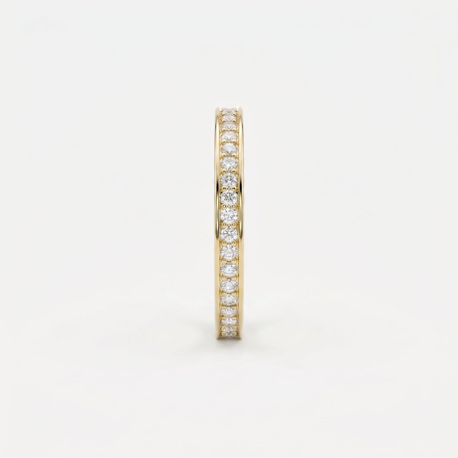 Side profile of yellow gold diamond eternity band showing slim width and secure diamond setting details